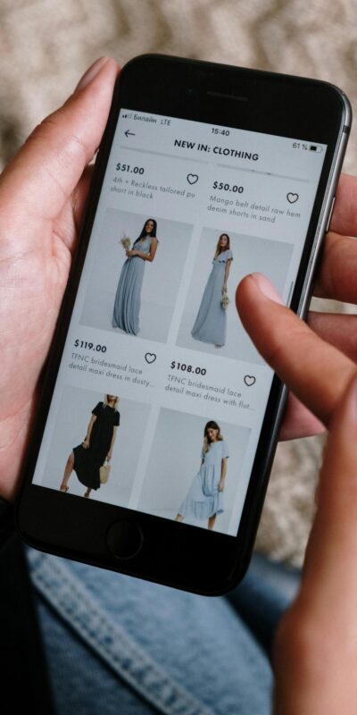 A person browsing clothing options on a smartphone for online shopping.