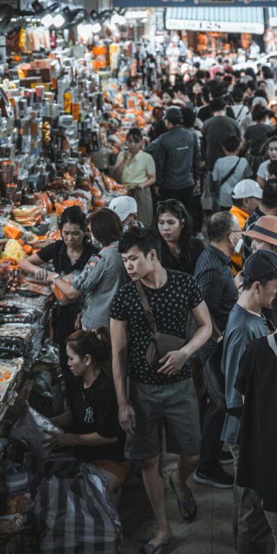 Busy indoor market filled with shoppers and colorful goods.