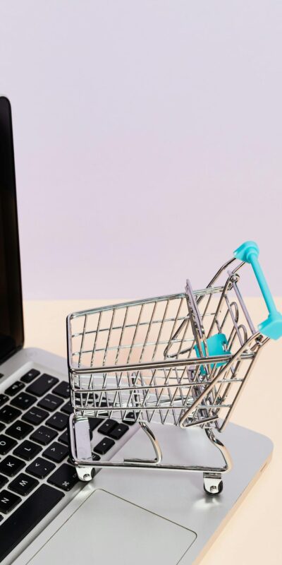 Mini shopping cart on a laptop symbolizes online shopping and e-commerce themes.
