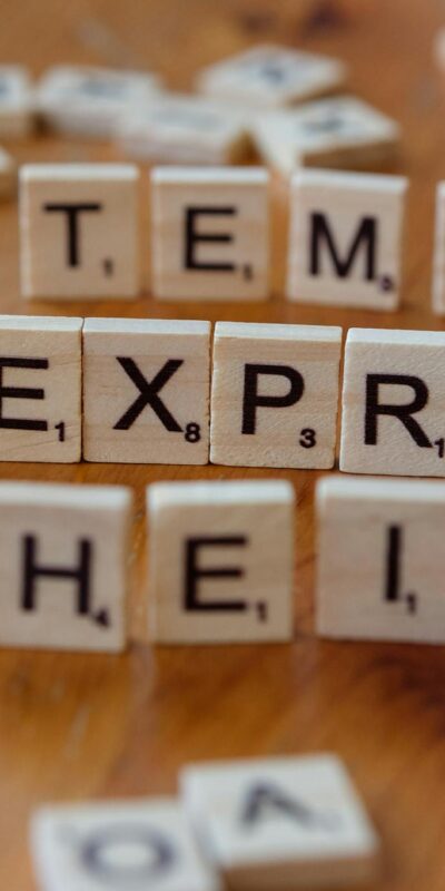 Wooden Scrabble tiles display popular e-commerce platforms on a wooden surface.